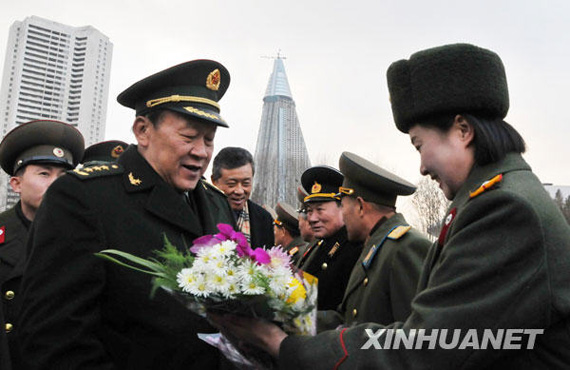 11月22日，中國國務(wù)委員兼國防部長梁光烈（左）在平壤祖國解放戰(zhàn)爭勝利紀(jì)念塔廣場接受獻(xiàn)花。新華社記者姚西蒙攝